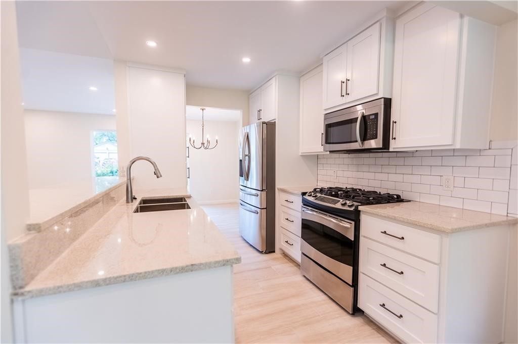 a kitchen with granite countertop a sink stove and refrigerator