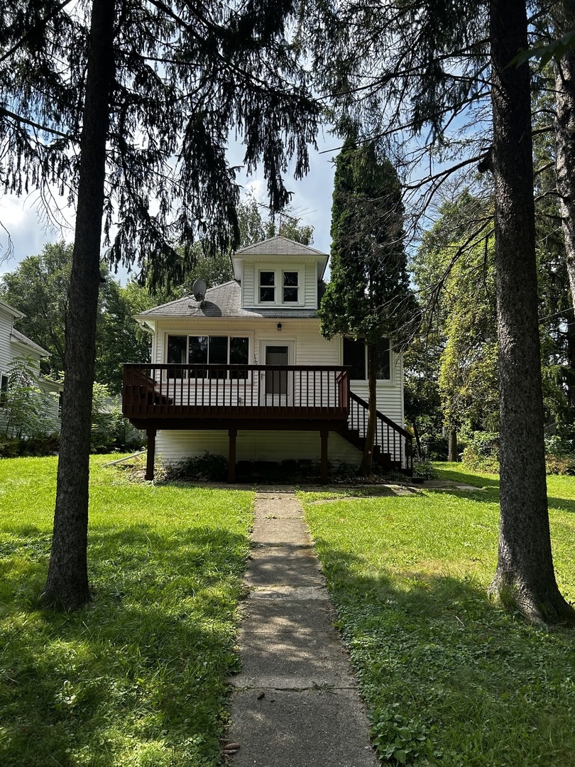 a view of a house with backyard and a tree