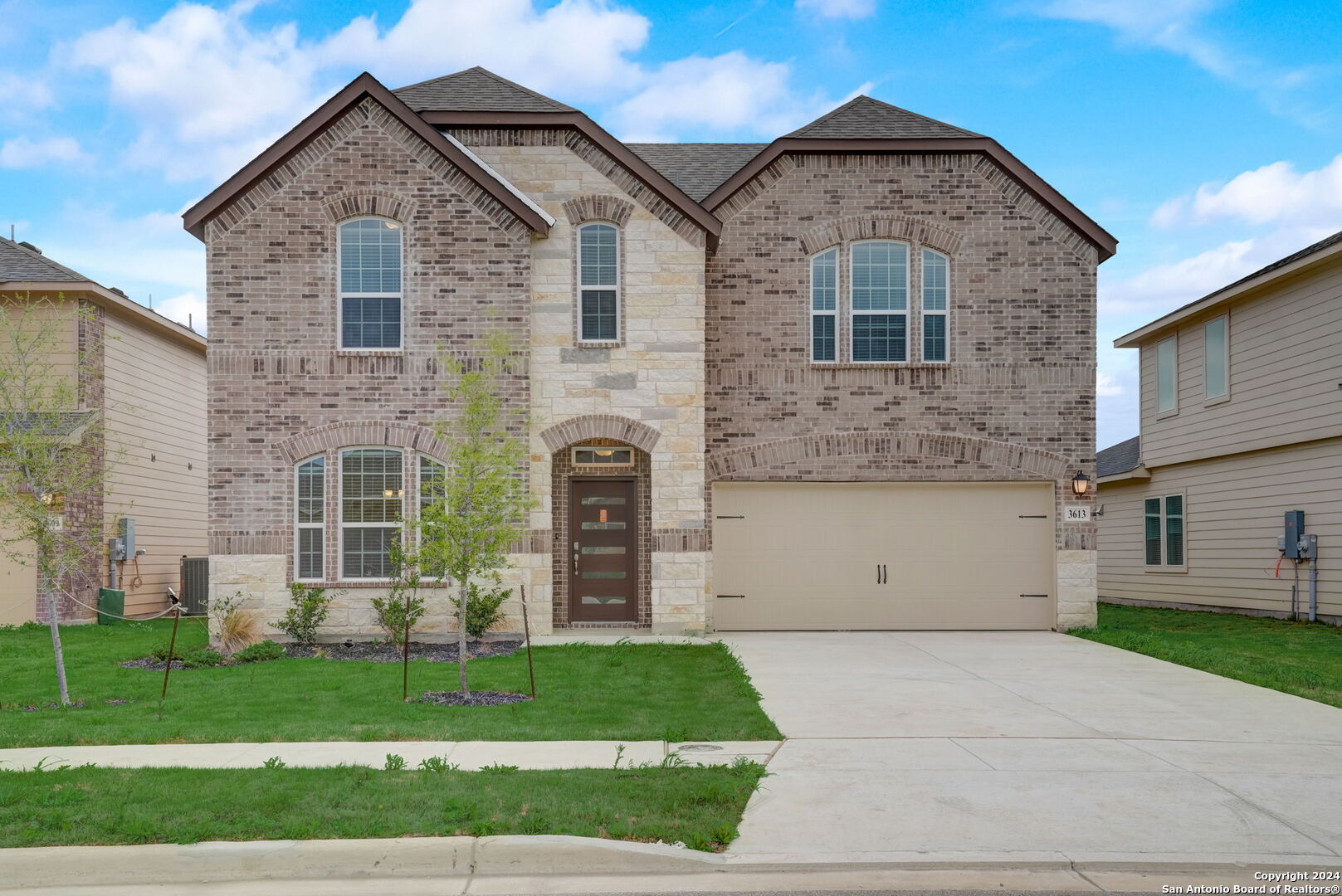 a front view of a house with a yard and garage