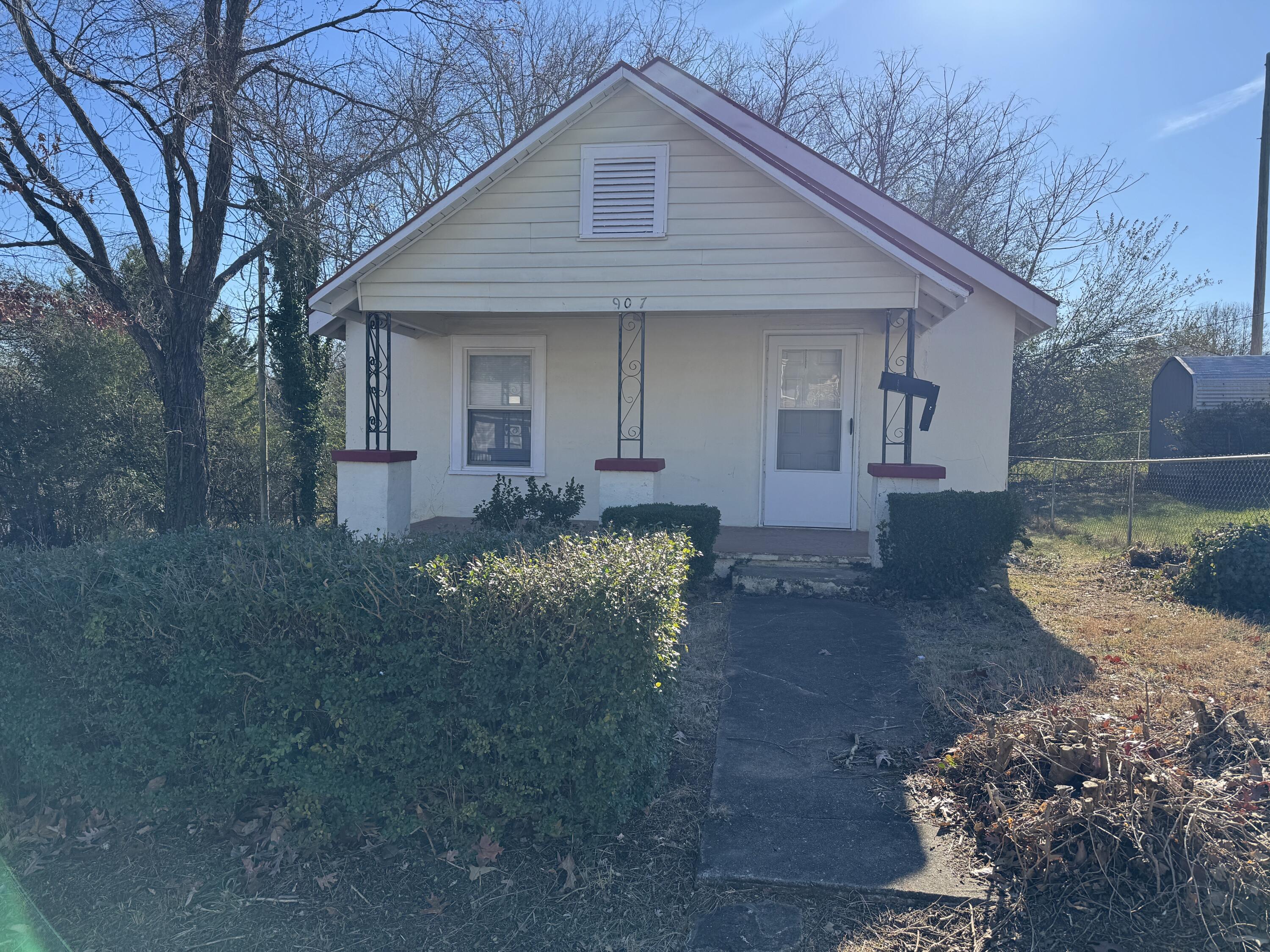 a front view of a house with a yard and trees