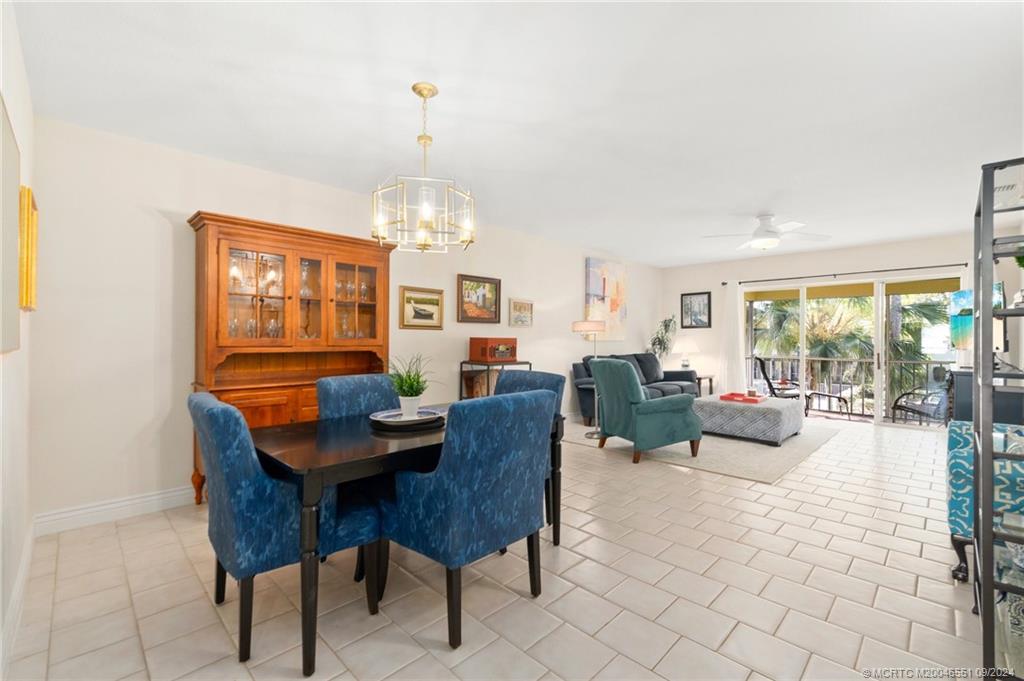 a living room with furniture a chandelier and a dining table