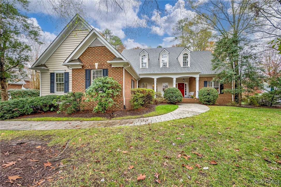 Cape cod home with a front lawn and covered porch