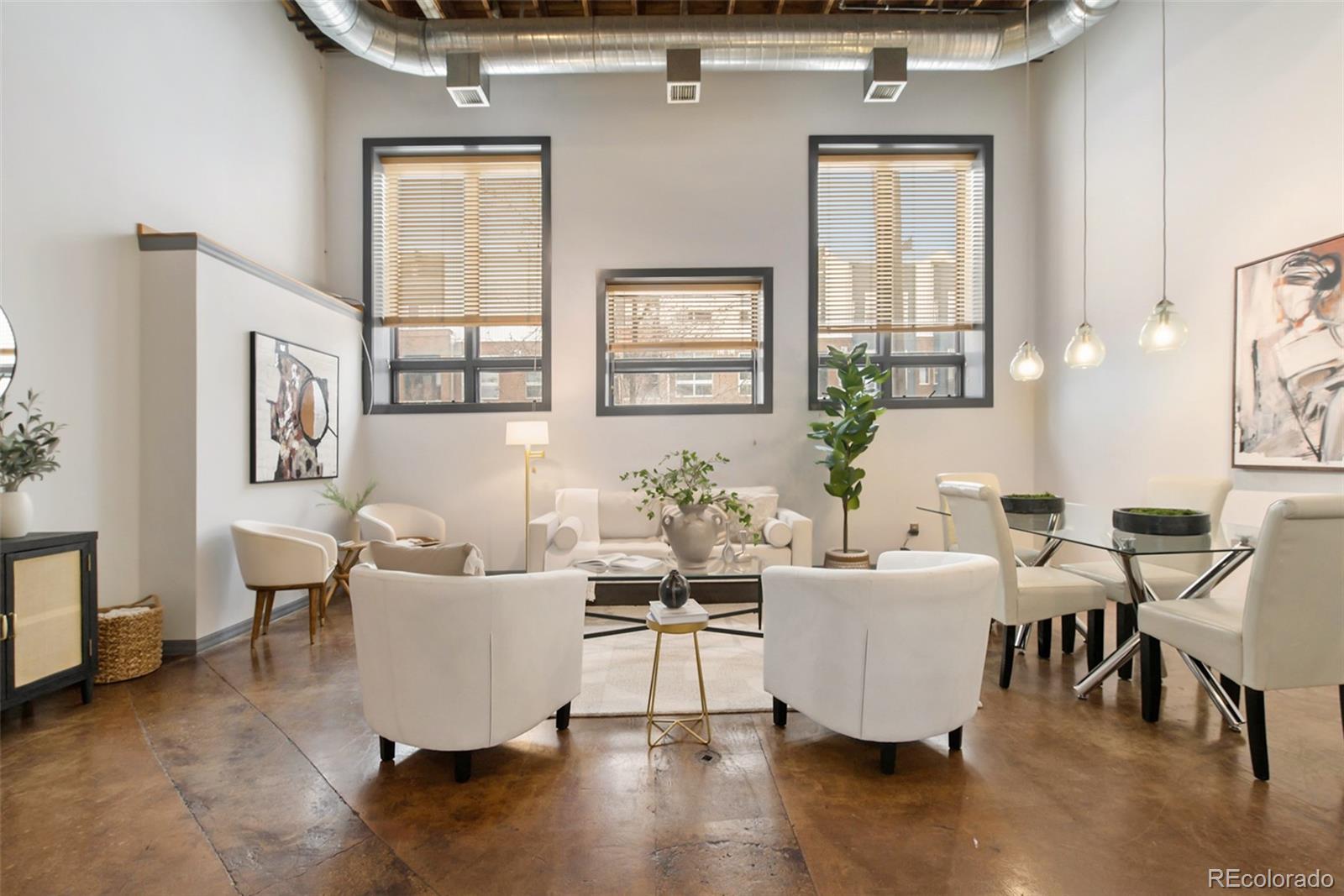 a living room with couches and a dining table with wooden floor