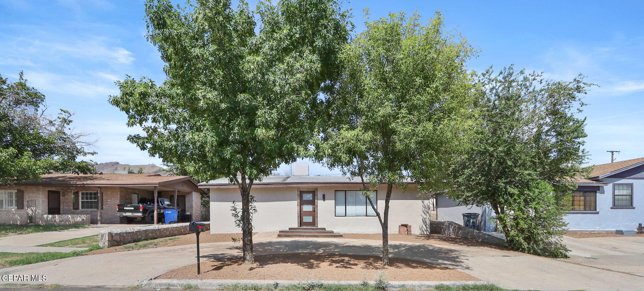 a front view of a house with a tree