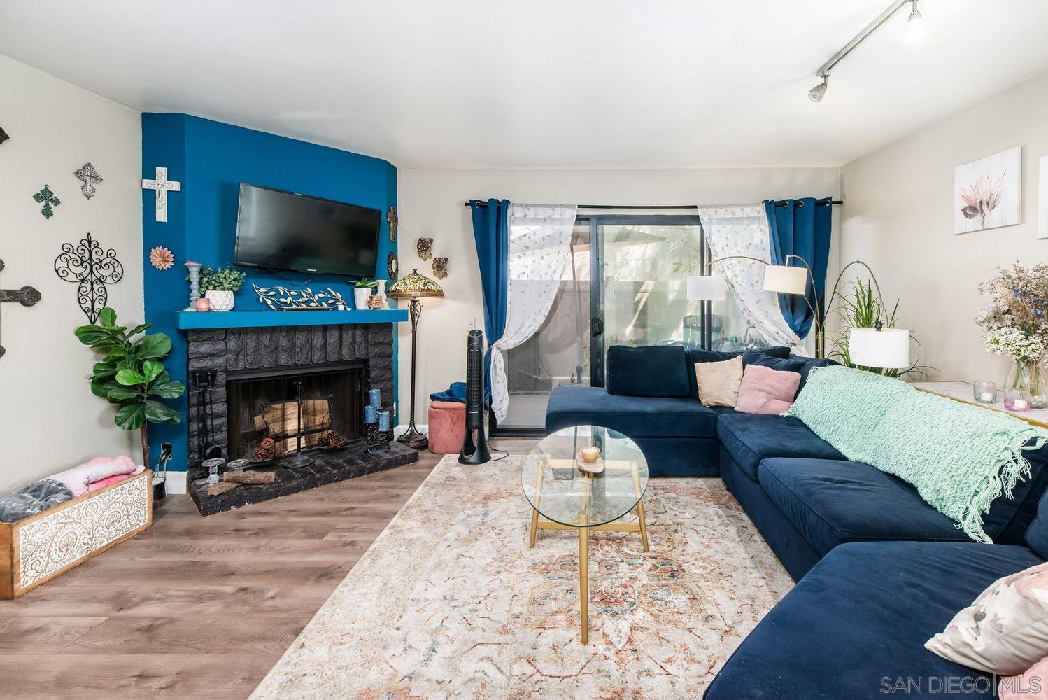 a living room with furniture a flat screen tv and a fireplace