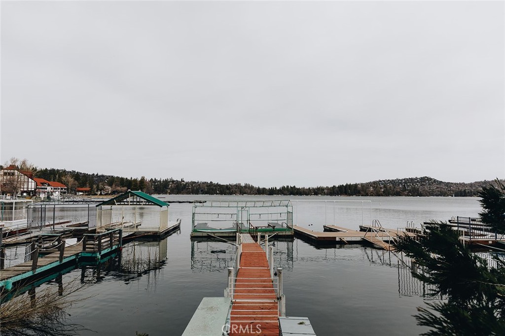 a view of a lake with table and chairs next to a road