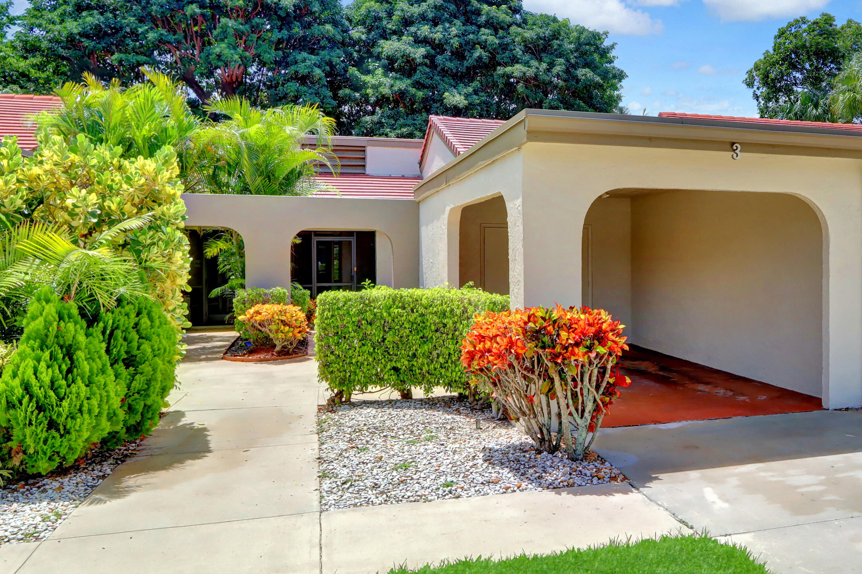 a front view of a house with a yard and potted plants