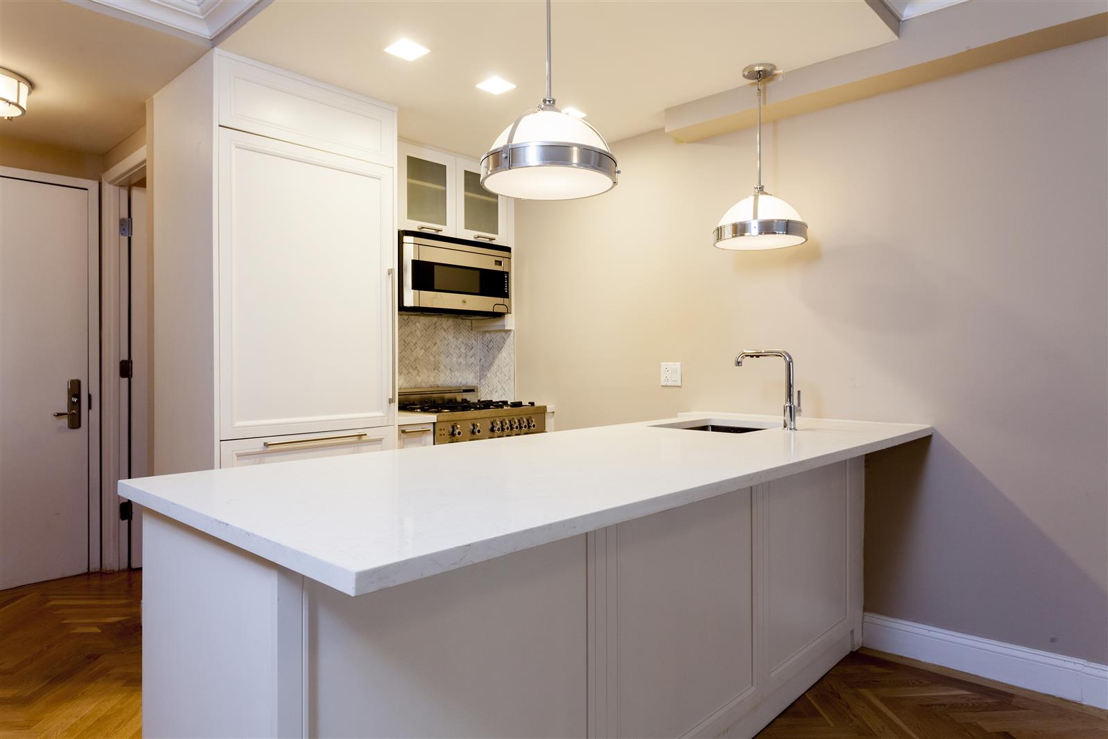 a kitchen with a sink a counter space and stainless steel appliances