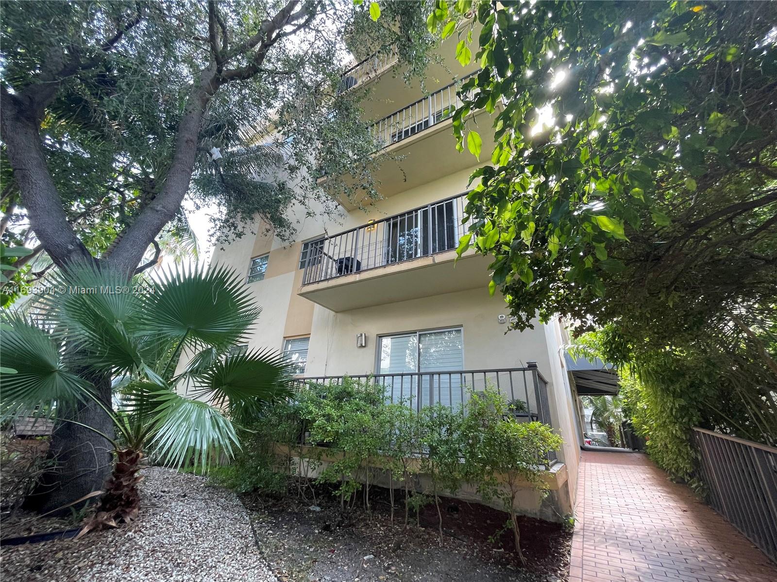 a front view of a house with plants and trees