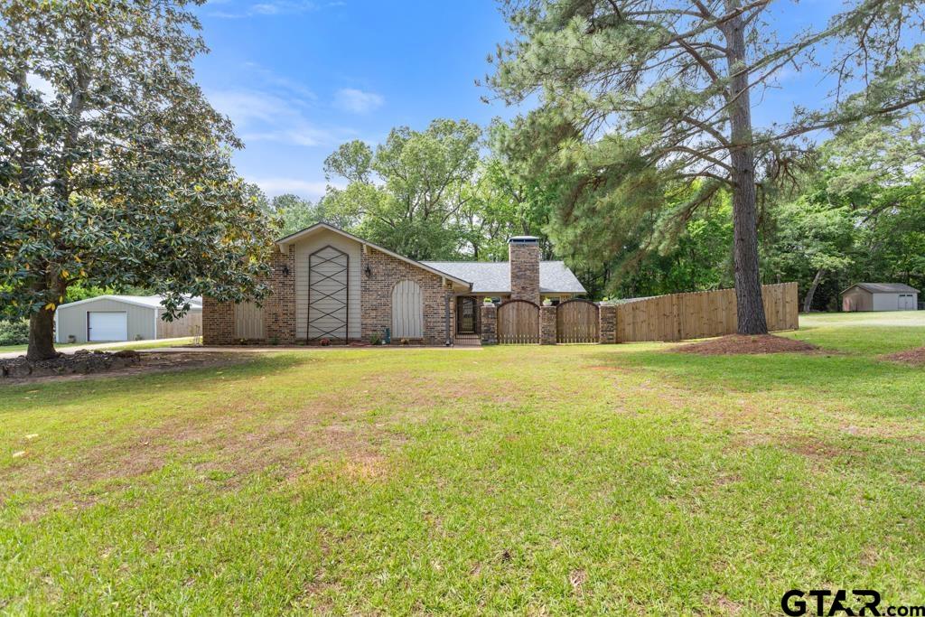 a front view of house with yard and trees in the background