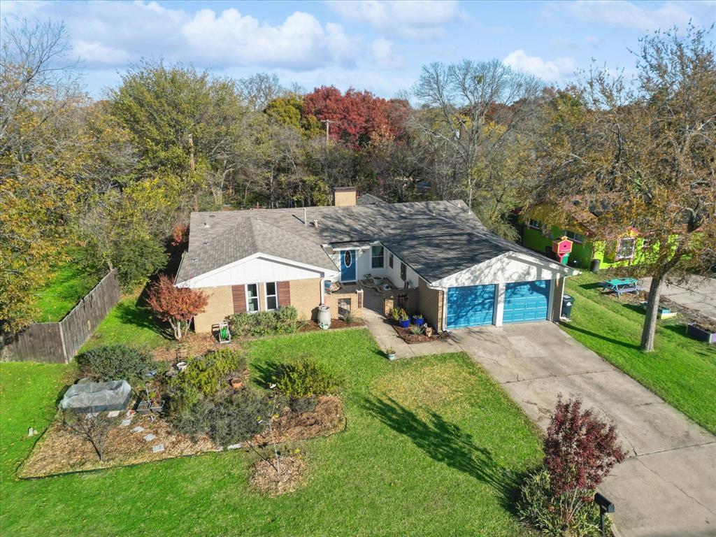 an aerial view of a house with a big yard and large trees