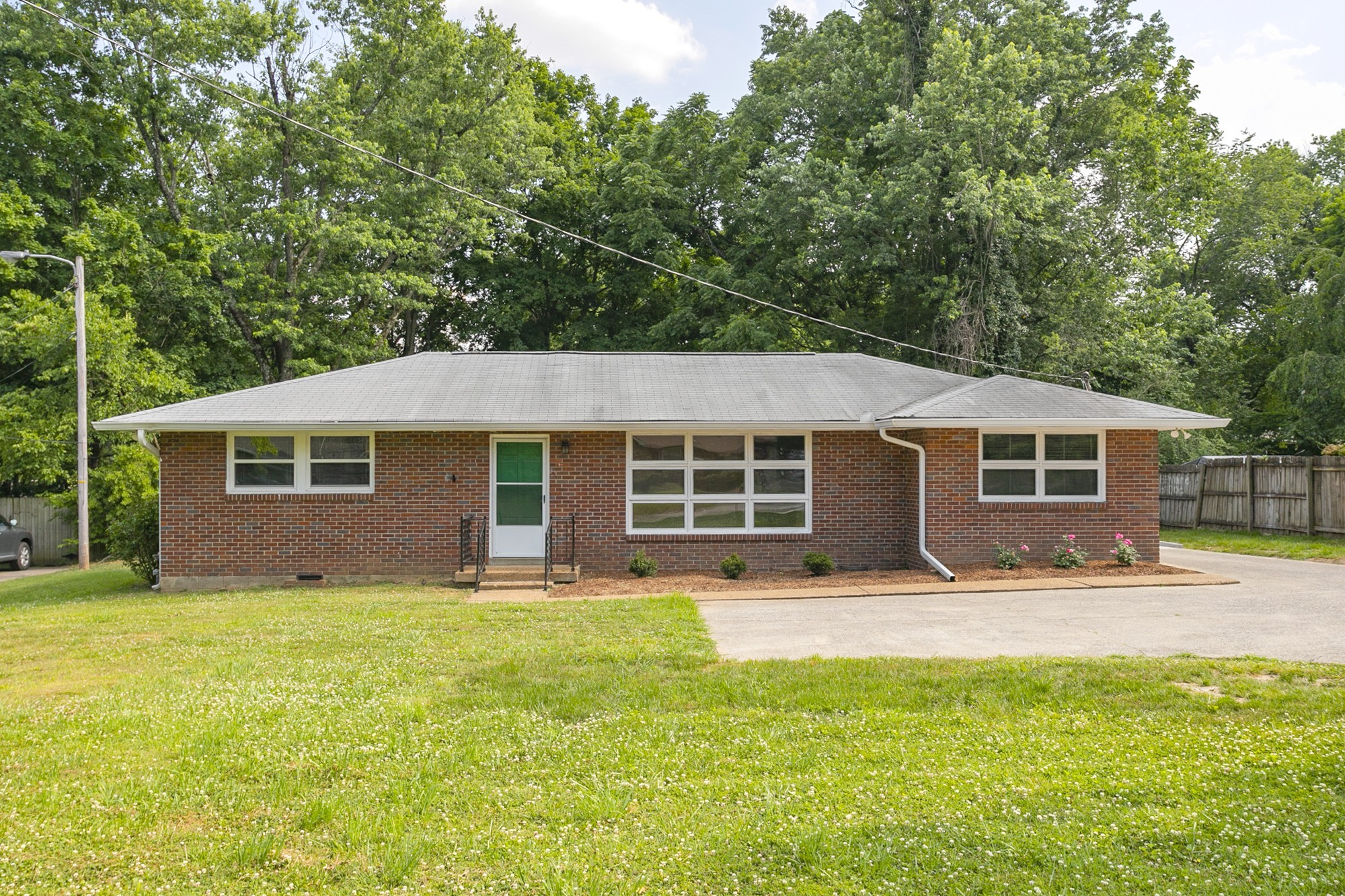 a front view of a house with yard and green space