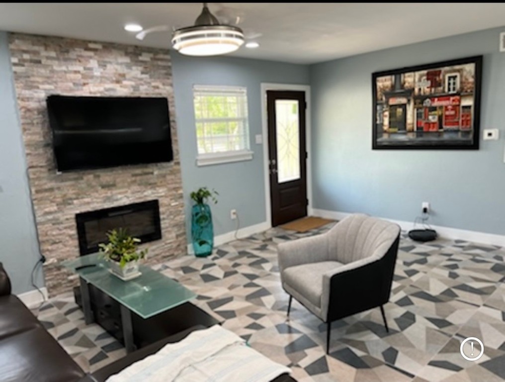 a living room with furniture a flat screen tv and a fireplace