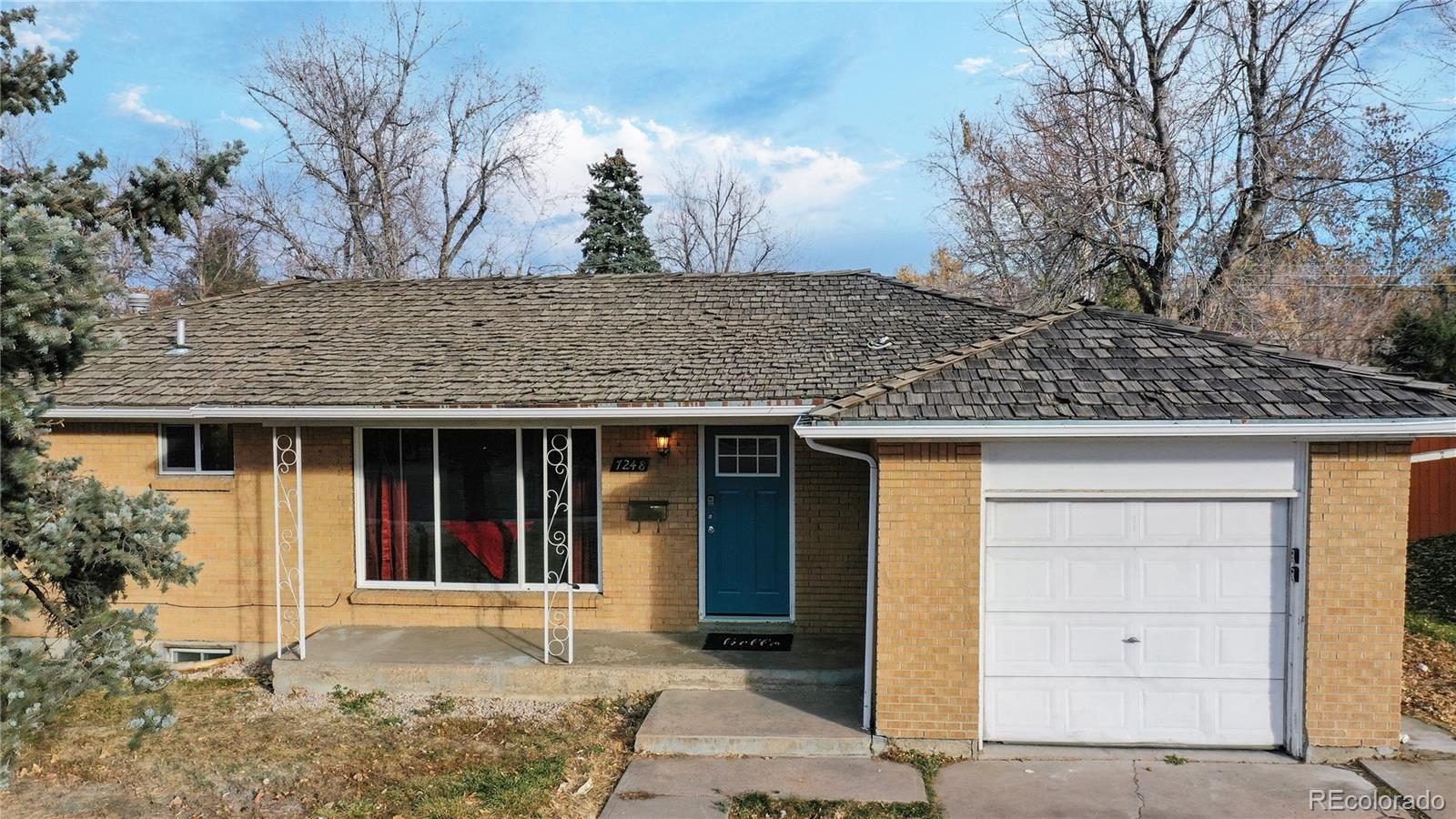 a front view of a house with a tree