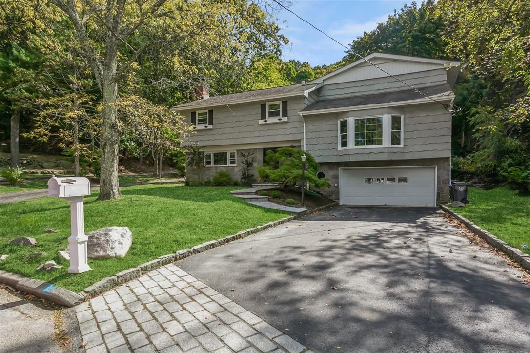 Raised ranch with a front yard and a garage