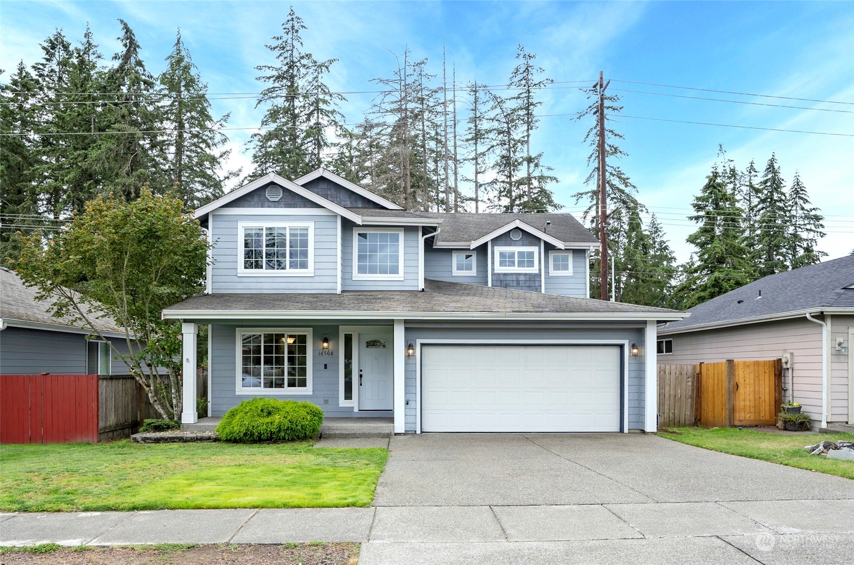 a front view of a house with a garden and trees