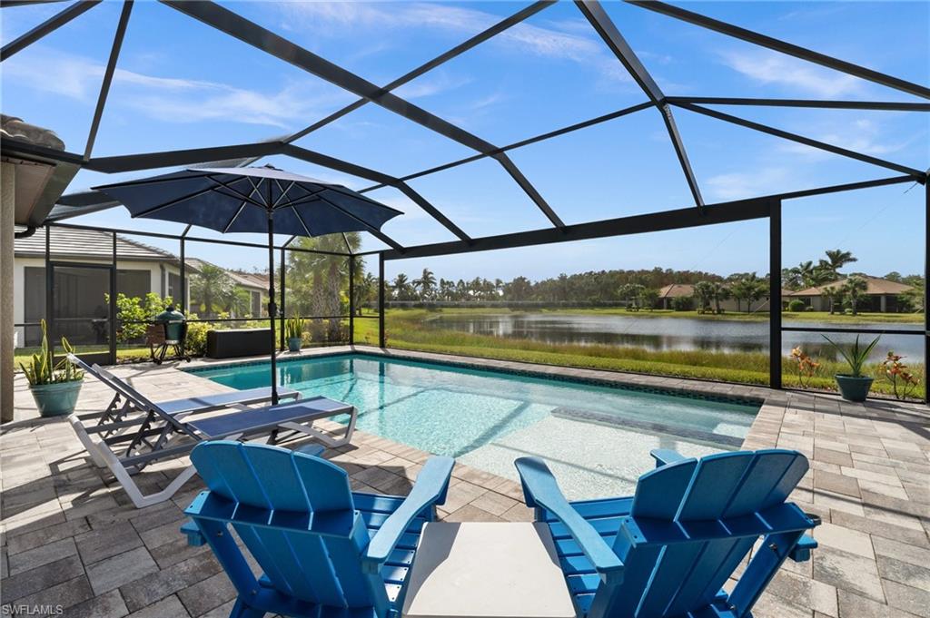 View of swimming pool featuring a lanai, a patio area, and a water view