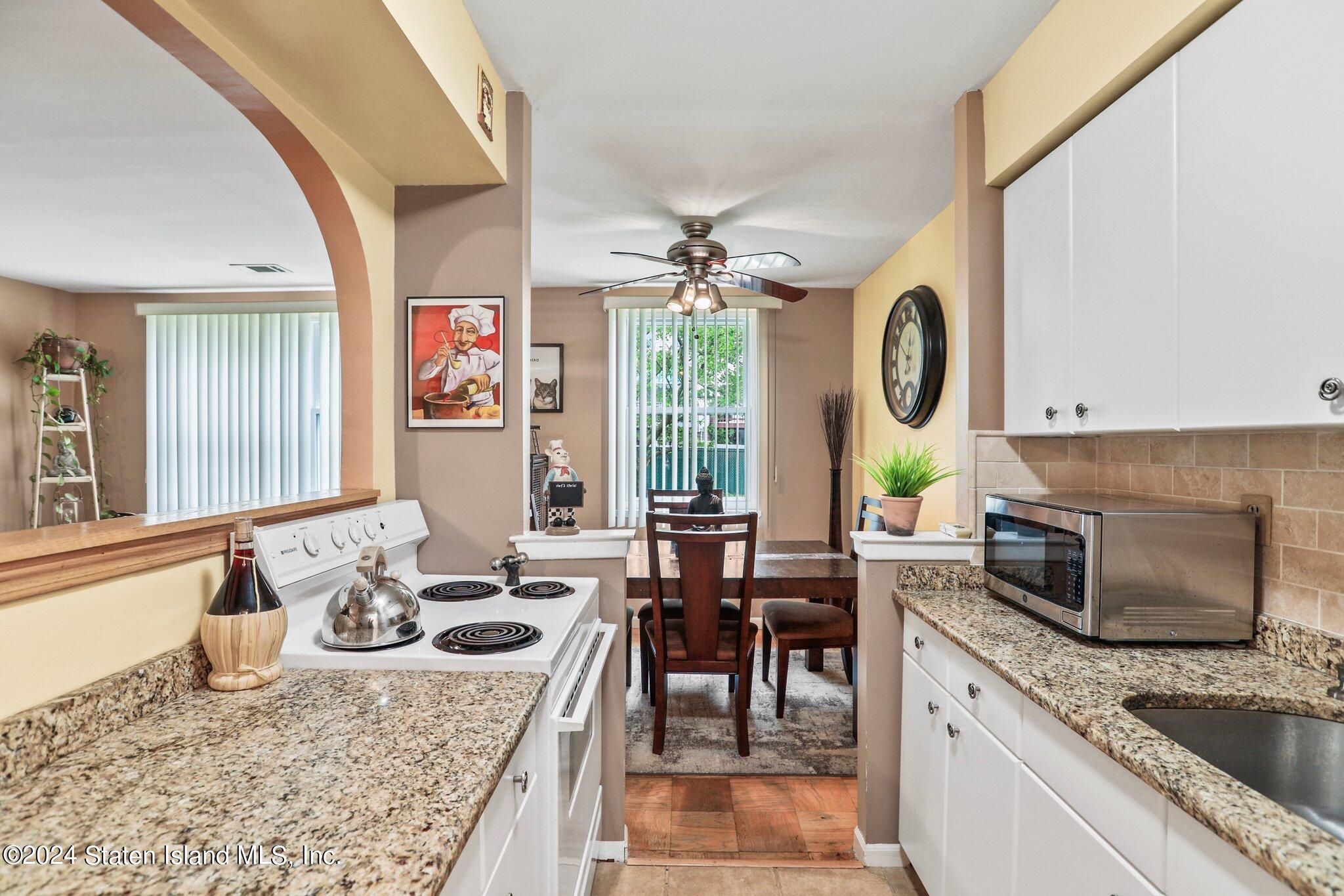 a kitchen with a granite countertop sink stove and cabinets