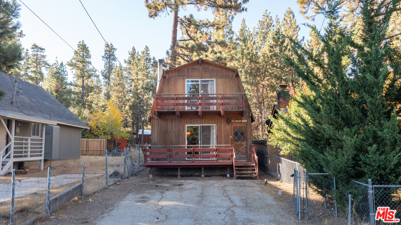 a front view of a house with a tree