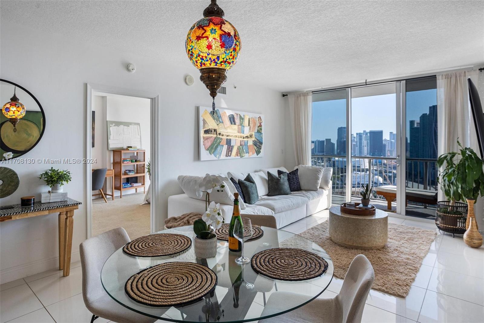 a living room with furniture a chandelier and a dining table