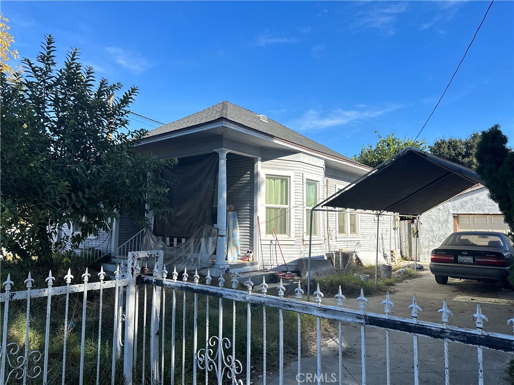 a view of a house with a small yard and wooden fence