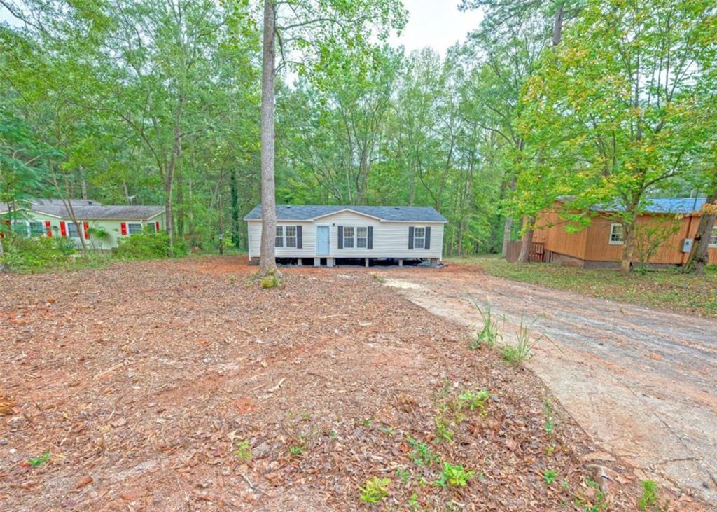 a view of a house with backyard and trees