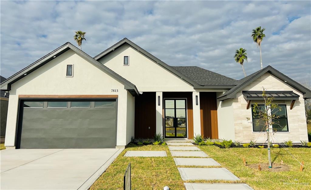 View of front of home featuring a garage and a front lawn