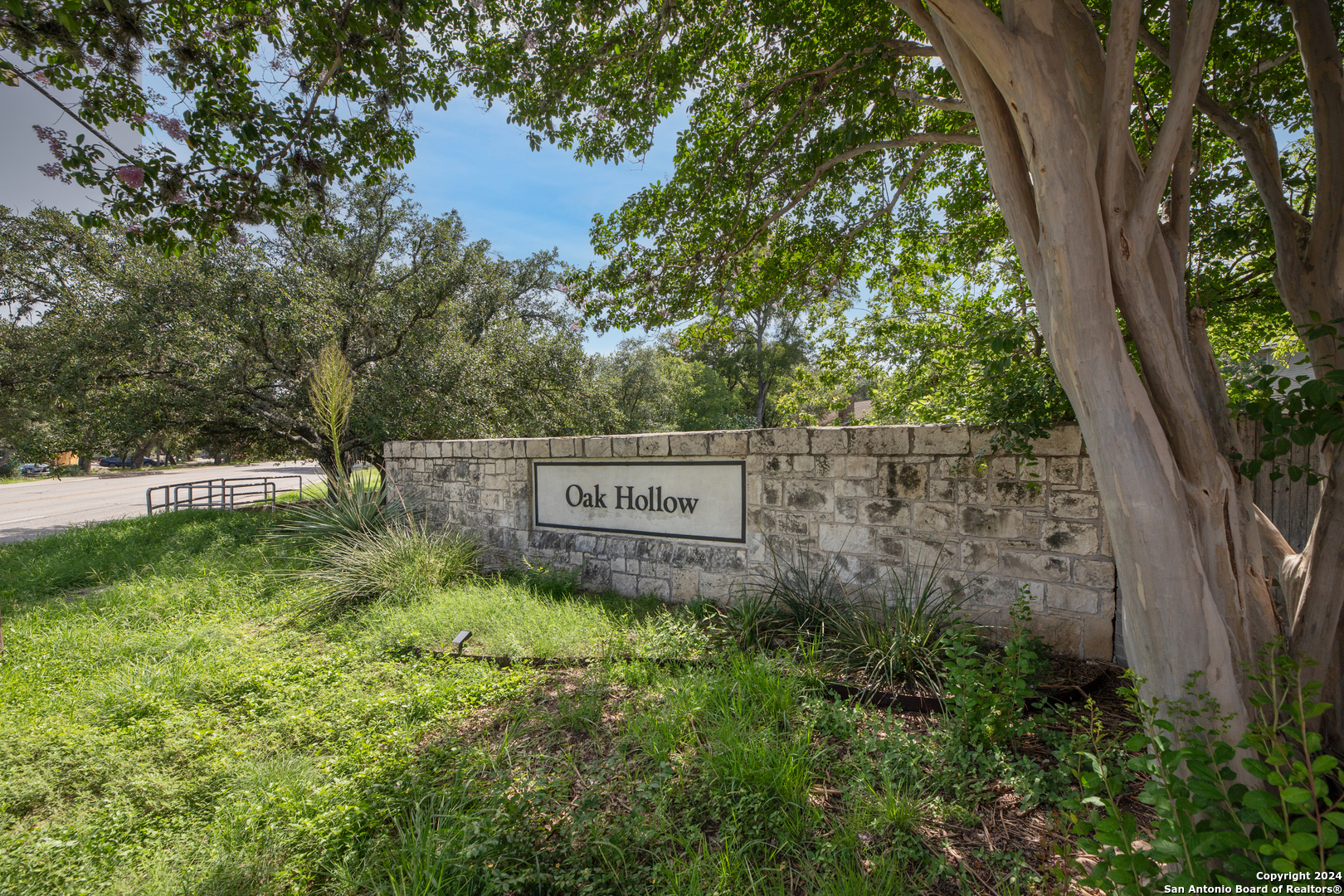 a sign that is sitting in front of a tree