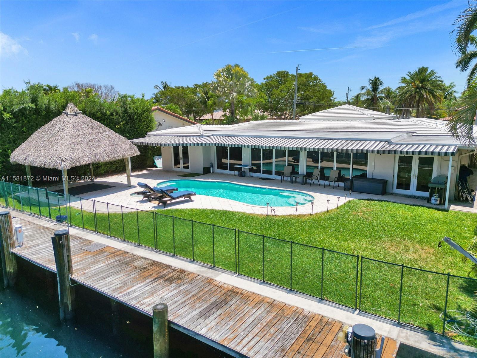 a view of a house with pool and chairs