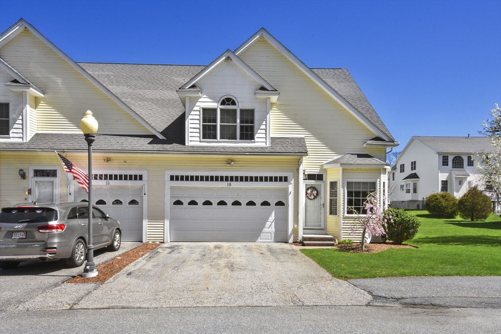 a view of a white house with a yard and garage