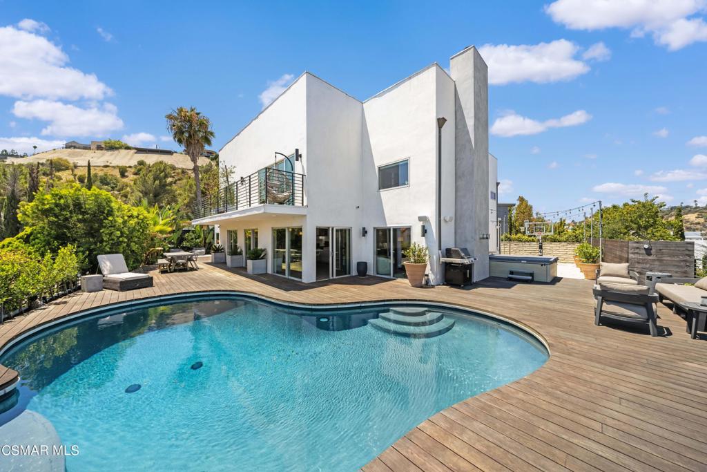 a view of a house with swimming pool and sitting area