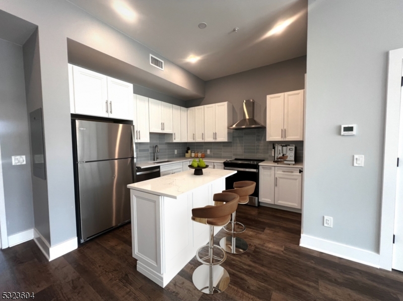 a kitchen with a refrigerator a sink and cabinets