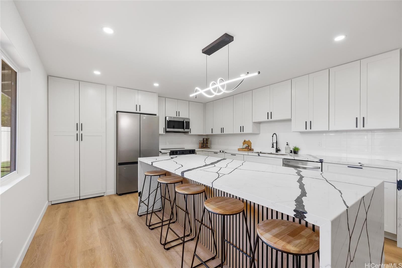 a kitchen that has a lot of cabinets a sink and a refrigerator