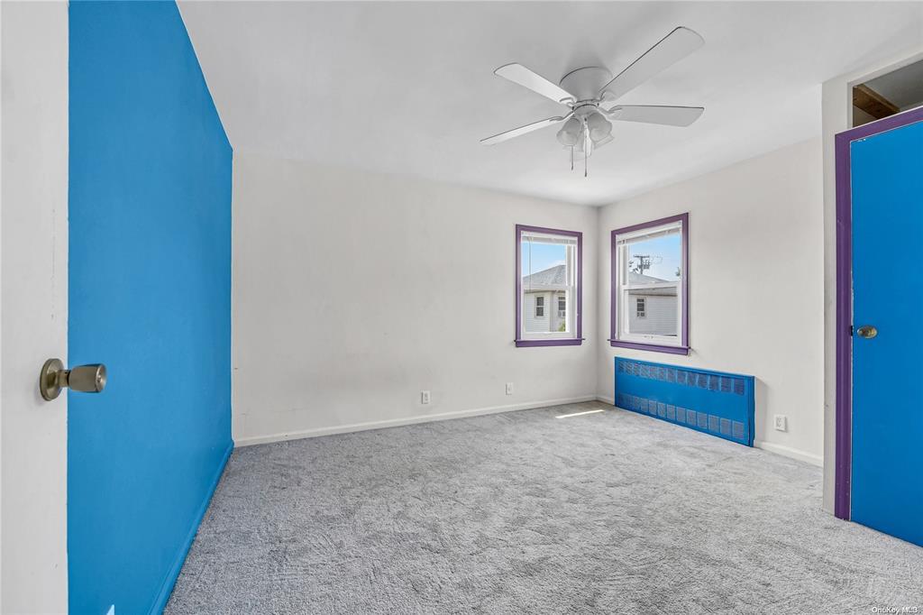 Empty room with ceiling fan and carpet floors