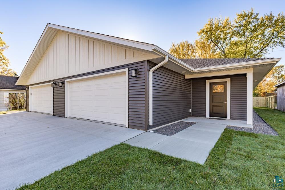 Single story home featuring a front yard and a garage