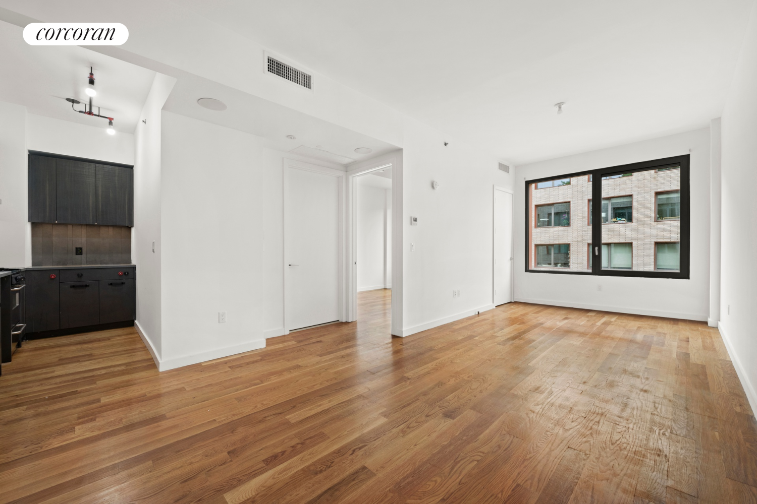 a view of an empty room with closet and a window