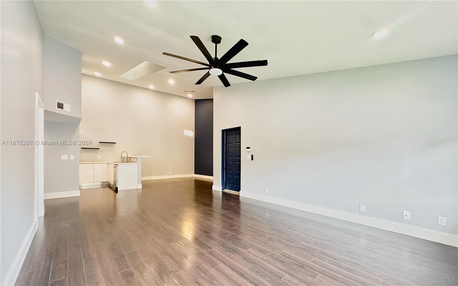 a view of a kitchen with wooden floor and a ceiling fan