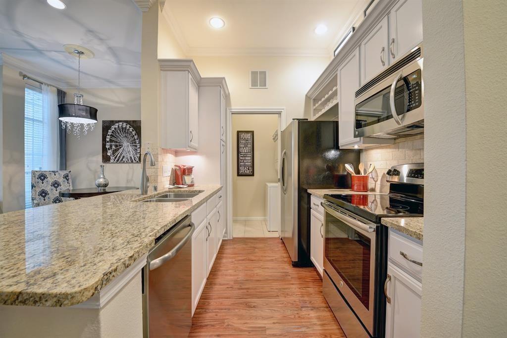 a large kitchen with stainless steel appliances granite countertop a stove and a sink