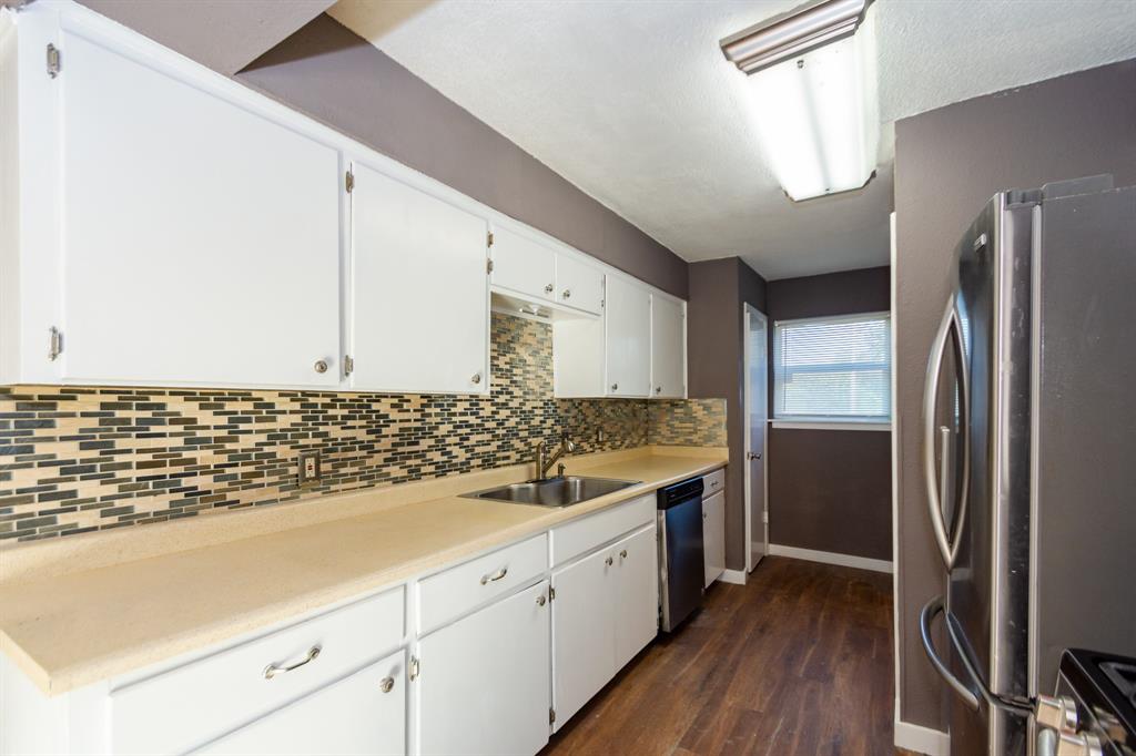 a kitchen with a sink stainless steel appliances a counter space and cabinets