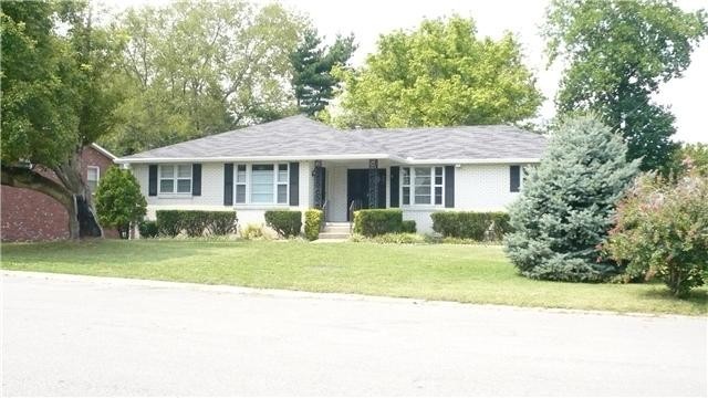 a front view of a house with a yard and potted plants