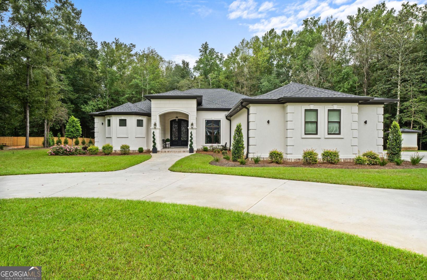 a view of a house with a big yard and large trees