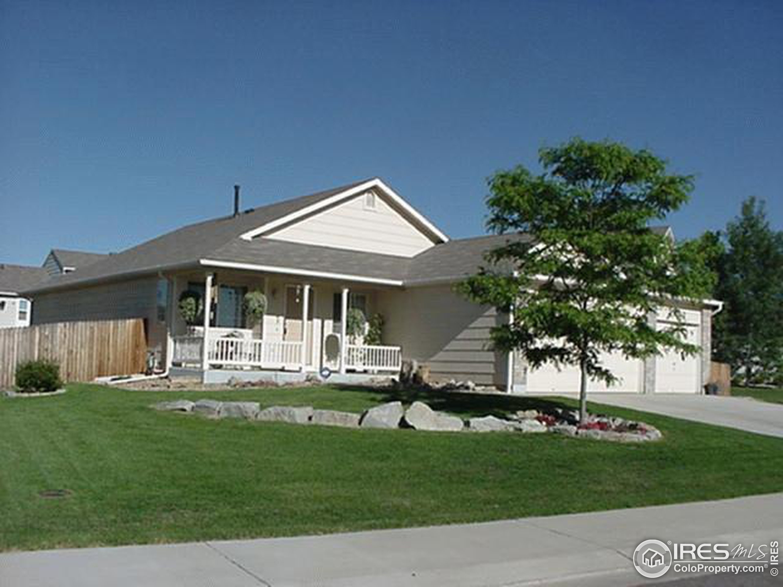 a front view of a house with a garden and trees