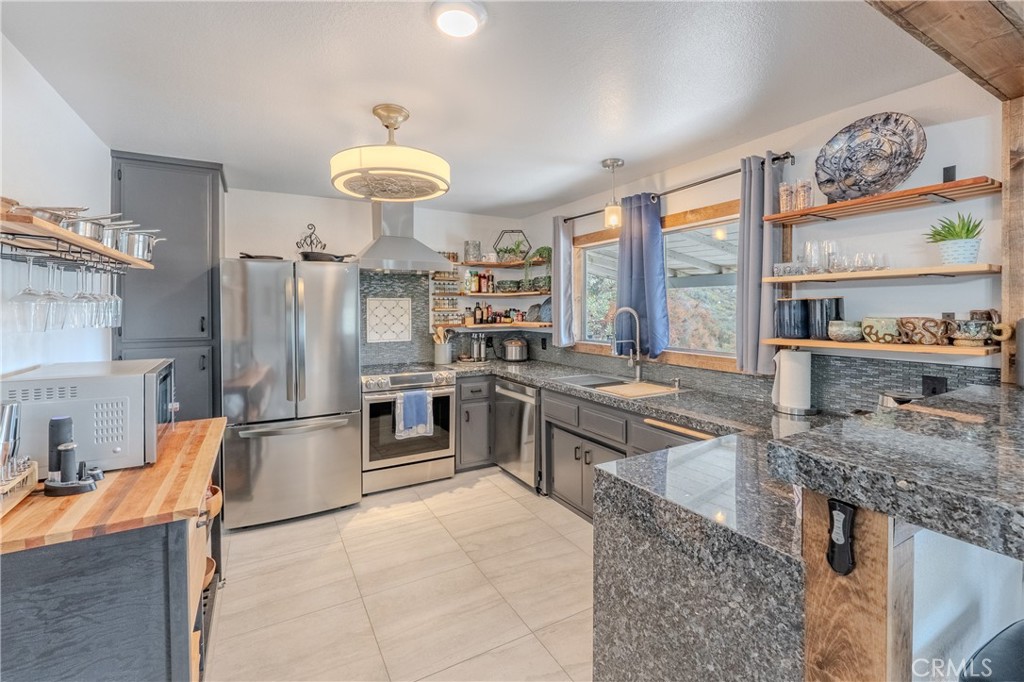 a kitchen with stainless steel appliances granite countertop a stove oven and a refrigerator