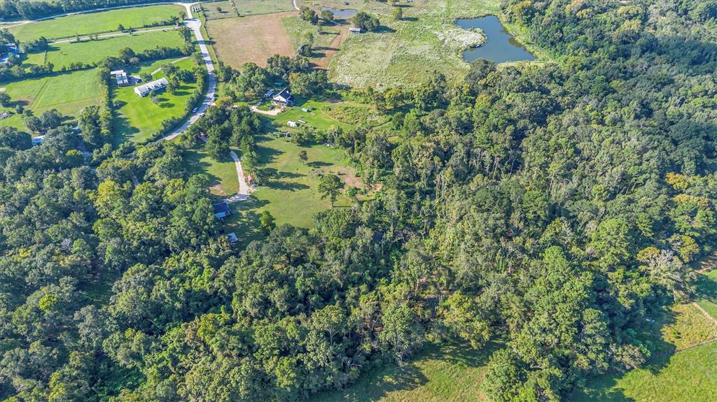 an aerial view of residential houses with outdoor space and trees