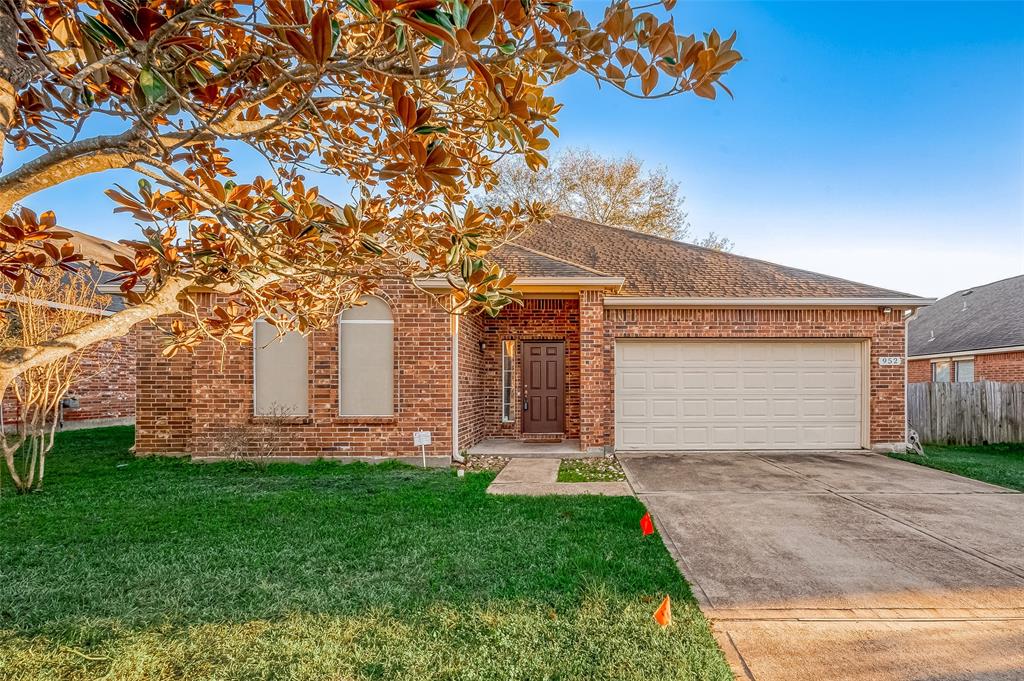 This neutral colored brick home features a covered front porch, two car garage and gutters on all sides.