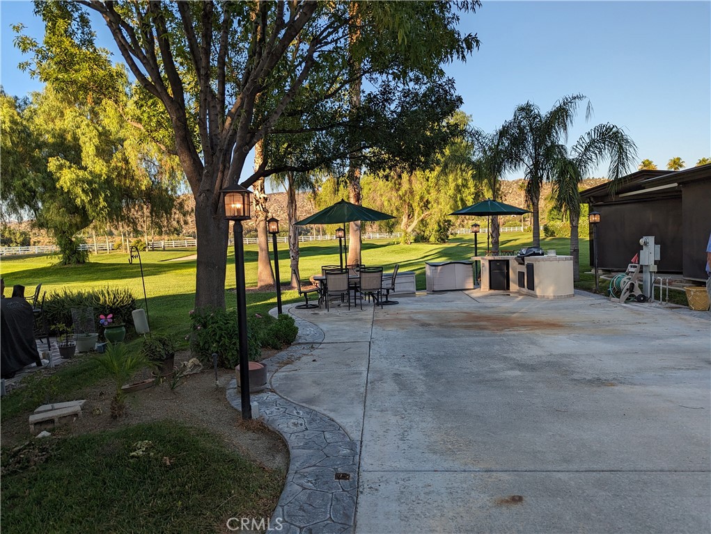 a view of a swimming pool with a patio and a yard