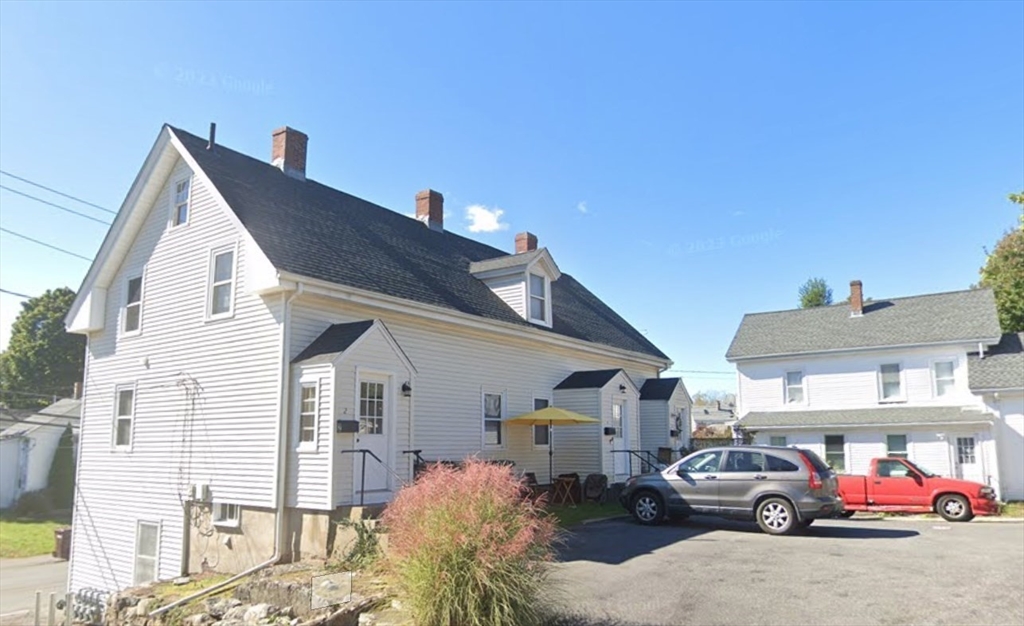 a front view of a house with cars parked