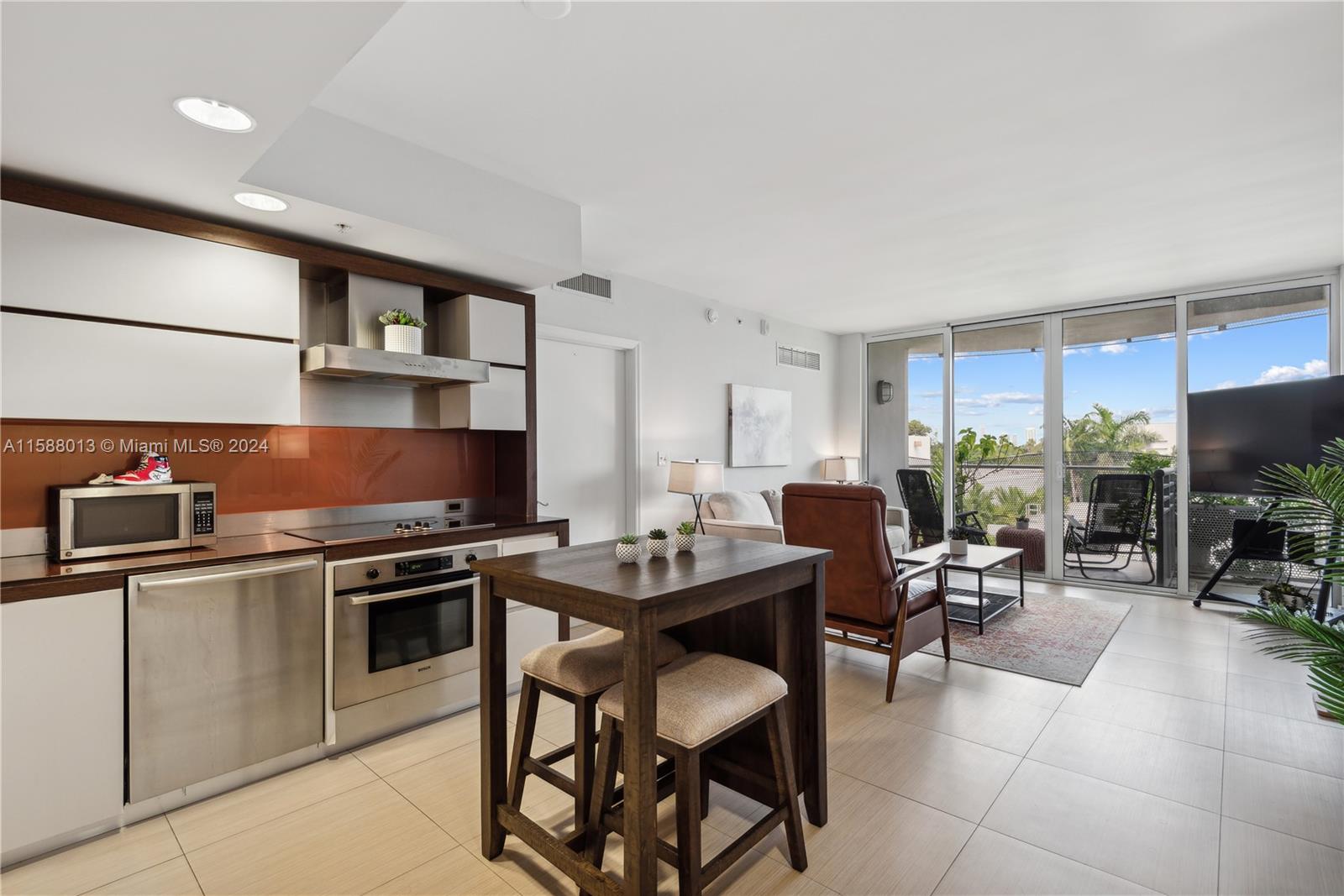 a kitchen with stainless steel appliances a table and chairs in it