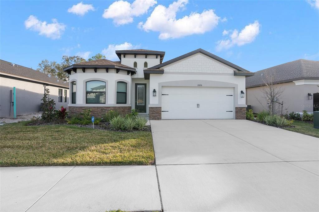 a front view of a house with a yard and garage