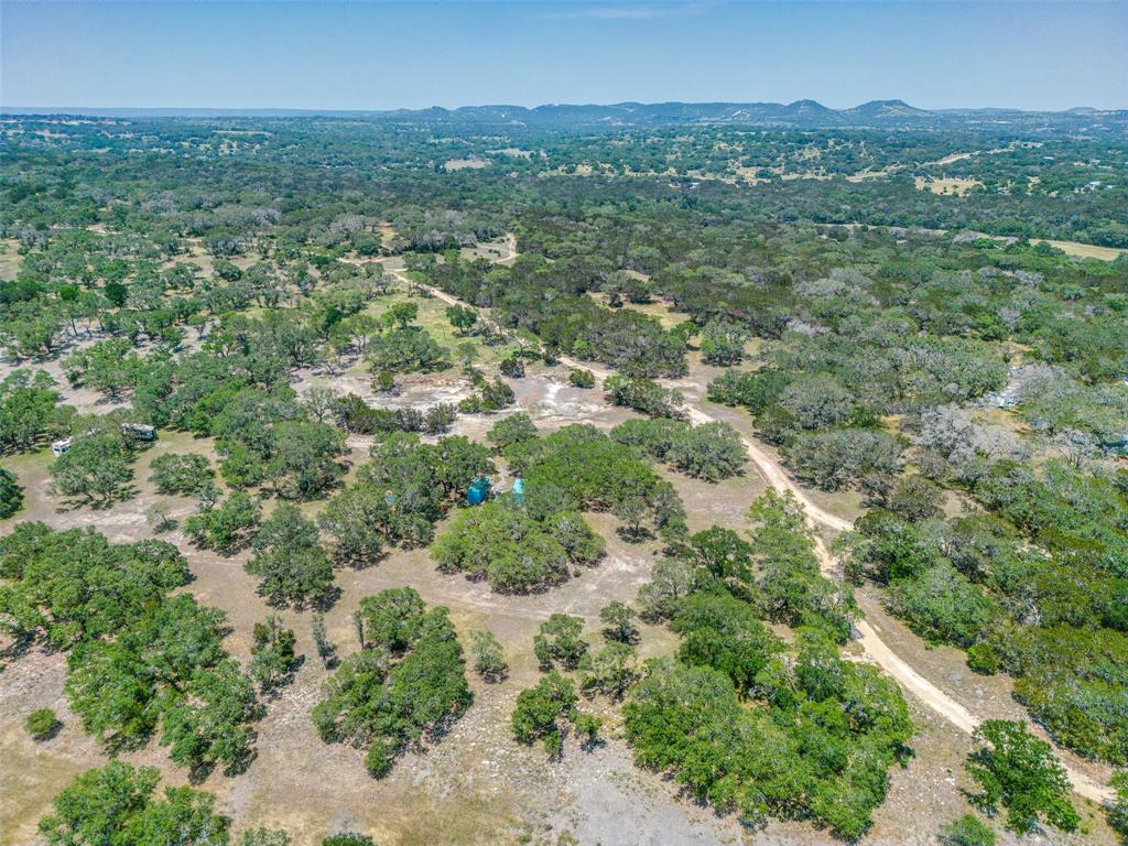 an aerial view of residential houses with outdoor space and trees